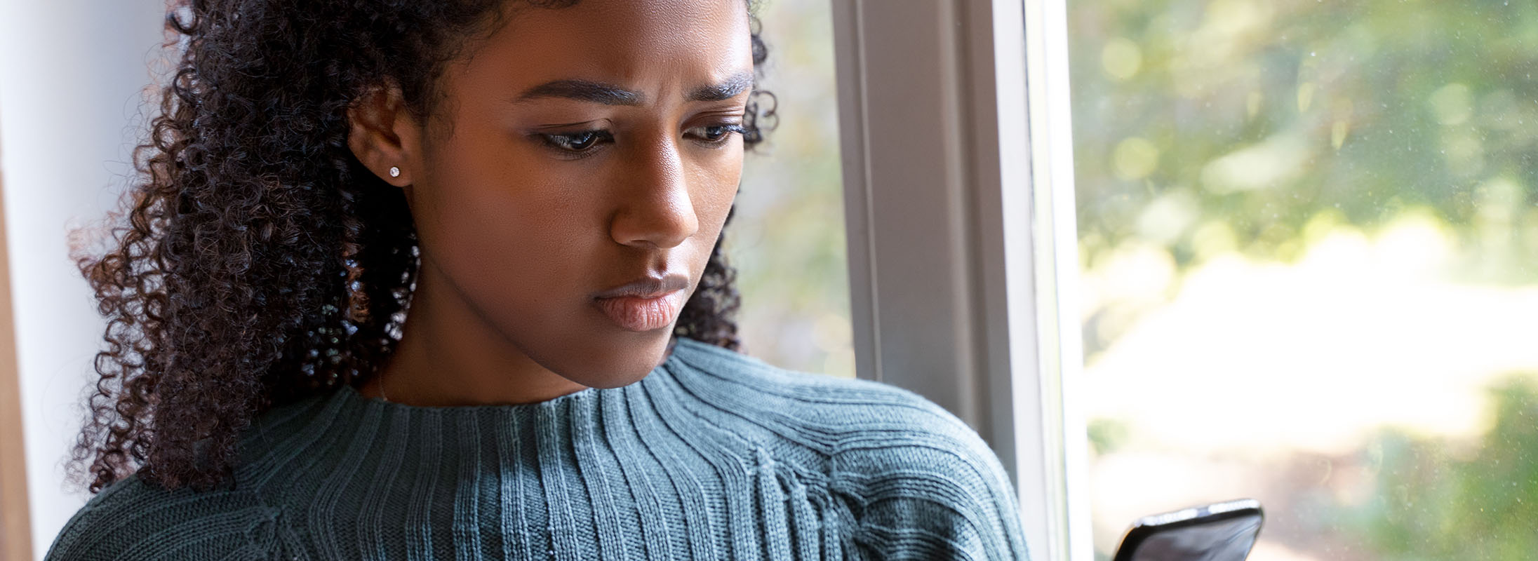 Black woman looking at mobile phone.